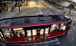 Zdjęcie przedstawia mężczyznę jadącego na dachu tramwaju