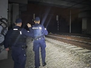 Na zdjęciu dwóch policjantów w pobliżu torów kolejowych