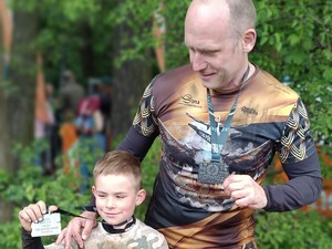 Na zdjęciu Łukasz Graniczny z synem, który w jednej ręce trzyma medal