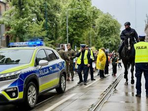Na zdjęciu policjanci Ruchu Drogowego, radiowóz, policjanci na koniach w trakcie zabezpieczenia przemarszu