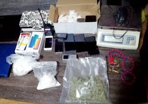 narkotyki w woreczkach, waga, laptopy, telefony komórkowe ułożone na podłodze