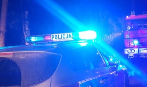 zdjęcie-noc, samochód policji i straży pożarnej z włączonymi niebieskimi światłami uprzywilejowania