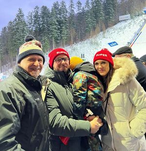 zdjęcie-rodzina pozuje do zdjęcia, w tle skocznia narciarska