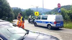 zdjęcie-dzień ,droga, policjanci wspólnie z pracownikami kolei rozmawiają z zatrzymanym kierowcą i wręczają ulotki