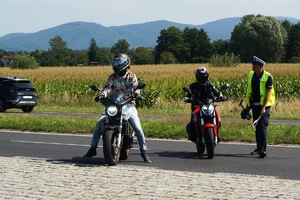 zdjęcie-policjant zatrzymuje motocyklistów, dwa motocykle, droga, słoneczna pogoda