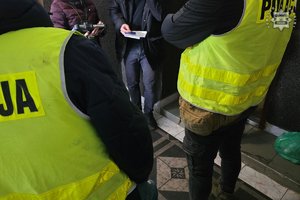 zdjęcie-pomieszczenie, policjanci sprawdzają dane osoby legitymowanej