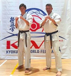 Szymon Bloch z ojcem pozują do zdjęcia, ubrani w karate-gi