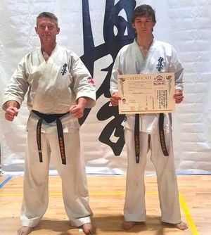 Szymon Bloch z ojcem pozują do zdjęcia, ubrani w karate-gi