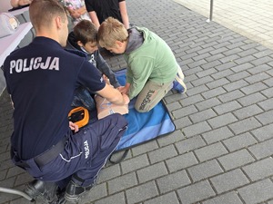 policjant uczy dzieci pierwszej pomocy