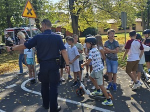słonecznie, park, policjanci uczą dzieci jeździć na hulajnogach