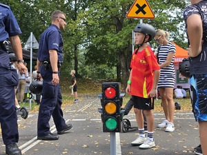 słonecznie, park, policjanci uczą dzieci jeździć na hulajnogach