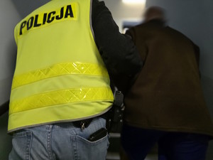 policjant prowadzi zatrzymanego