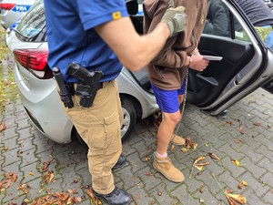 policjant prowadzi zatrzymanego