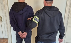 zatrzymana osoba pilnowana przez policjantów