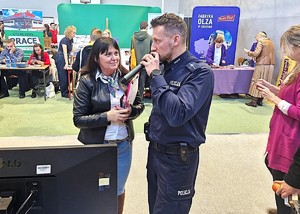 sala gimnastyczna, policjant przemawia przez mikrofon