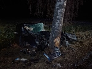 zdjęcie-noc, mocno uszkodzone auto, przed nim drzewo