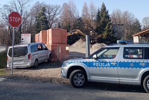 Zdjęcie z miejsca zdarzenia-dzień, słonecznie, radiowóz policji, mercedes, który uderzył w paletę z materiałami budowlanymi - pustakami.