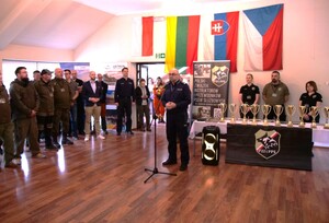 uczestnicy zgromadzeni na sali, osoba w mundurze przemawia do zebranych