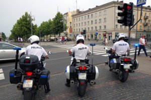 trzech motocyklistów policyjnych na motocyklach tyłem do fotografującego