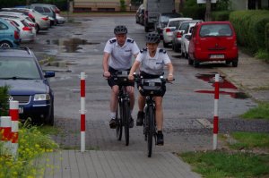 dwoje policjantów jedzie rowerami po drodze