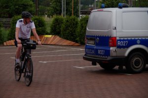 policjant na rowerze w tle radiowóz