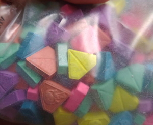 kolorowe tabletki (ekstazy) w kształcie trójkąta zamknięte w woreczku