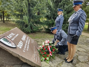 Delegacja policjantów składa wiązankę kwiatów pod pomnikiem