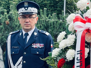 Komendant Wojewódzki Policji z Katowic stoi przy wiązance kwiatów