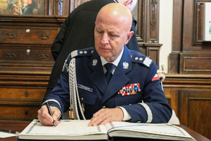 Generał Polskiej Policji robi wpis do policyjnej kroniki