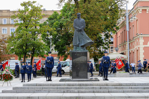 Pomnik Piłsudskiego na placu Biegańskiego otoczony policjantami i delegacją składającą wiązankę kwiatów