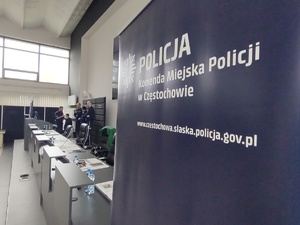 Napis Komenda Miejska Policji w Częstochowie za którym stoją policjanci