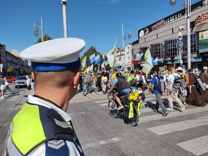 Policjant zabezpiecza przemarsz pielgrzymów przez jezdnię