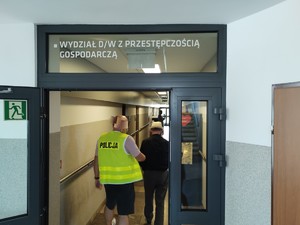 Policjant doprowadza zatrzymanego