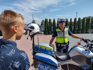 Policjant przy motocyklu służbowym rozmawia z chłopcem