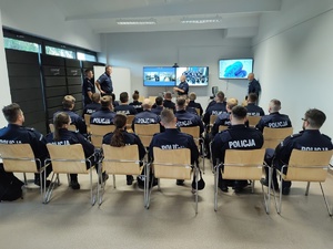 Policjanci siedzą w sali szkoleniowej podczas wykładu