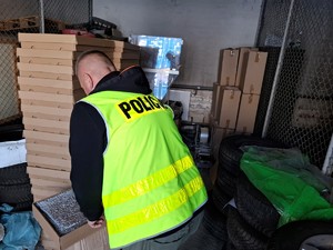 Zabezpieczony towar w magazynie dozorowany przez policjanta