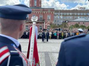 Policjanci prezentują poczty sztandarowe podczas uroczystości