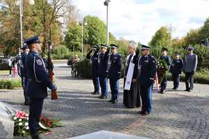 Dowódca kompani honorowej prowadzi policjantów ulicą miasta