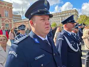 Policjanci w umundurowaniu wyjściowym stoją obok siebie (ojciec z synem)