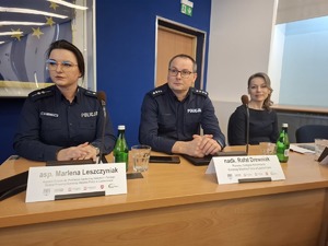 Zastępca Komendanta Miejskiego i policjantka siedzą w wyznaczonych miejscach