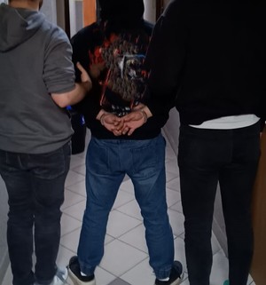Policjanci nieumundurowani doprowadzają zatrzymanego