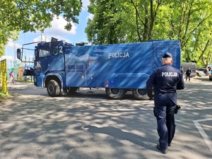 Policjant zabezpiecza wjazd armatki wodnej