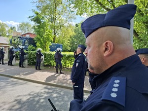 Policjanci podczas zabezpieczenia stoją na drodze