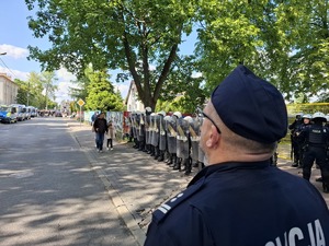 Policjant przygląda się zabezpieczeniu drogo przez policjantów