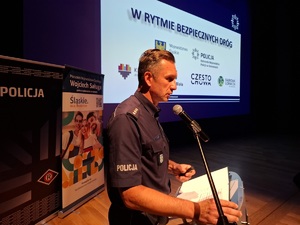 Policjant z mównicy przemawia do mikrofony