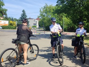 Policjanci na rowerach rozmawiają z rowerzystką