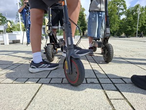 Koła hulajnóg przy których znajdują się nogi chłopców