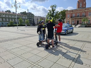 Policjanci rozmawiają z chłopcami którzy stoją przy hulajnogach