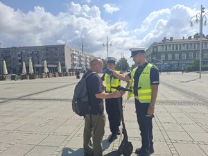 Policjanci badają stan trzeźwości z mężczyzny na hulajnodze