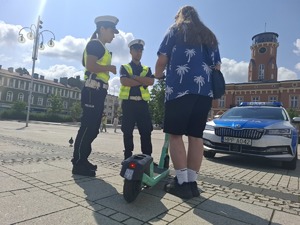 Policjanci rozmawia z mężczyzną na hulajnodze